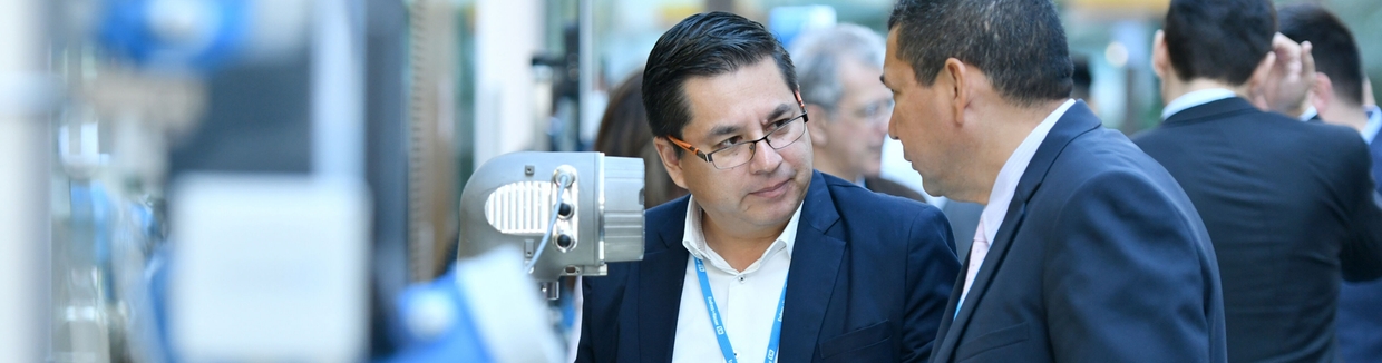 People discussing at a Endress+Hauser event in front of a exhibit.